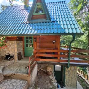 a small house with a green door and a porch at Vikendica Breza in Zaovine