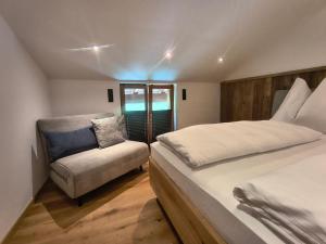 a bedroom with a large bed and a chair at biohof Stiedler in Sankt Johann in Tirol