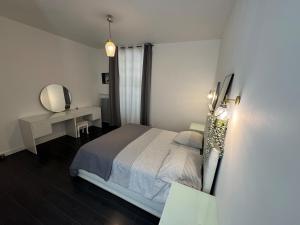 a bedroom with a bed and a desk and a mirror at Bellavita in Courpière