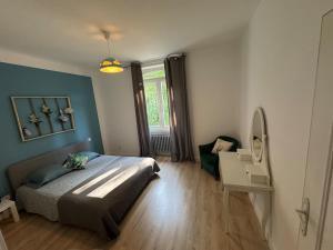 a bedroom with a bed and a chair in it at Bellavita in Courpière