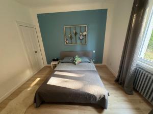a bedroom with a bed in the corner of a room at Bellavita in Courpière +1 photo