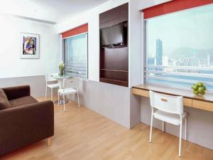 a living room with a couch and a kitchen with a table at ibis Hong Kong North Point in Hong Kong