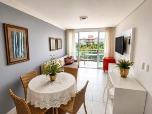 a dining room with a table and chairs and a television at Apto. Palm Beach, 300M Beach Park in Aquiraz