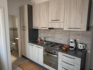 a kitchen with white cabinets and a stove top oven at Casa Paloma Free Parking in Bolsena +7 photos