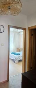 a room with a bedroom with a bed and a clock at Алекс 2 in Pomorie +2 photos