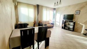 a living room with a couch and a table and chairs at Алекс 2 in Pomorie