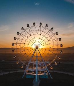 a ferris wheel with the sunset in the background at Yura Hostel in Darhan
