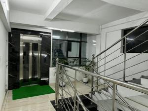 a staircase with a green door in a building at Roys Rooms in Kumarakom