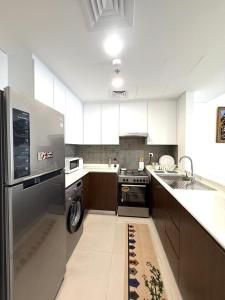 a large kitchen with a stove and a sink at Ajmal Makan City in Sharjah