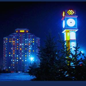 a clock tower in front of a building at night at Yura Hostel in Darhan +22 photos