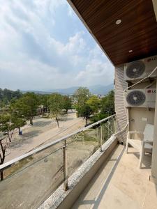 a balcony of a house with a view of a park at Petal & Peak Stays in Rājpur +30 photos