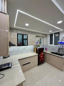 a kitchen with white counter tops and a refrigerator at Petal & Peak Stays in Rājpur