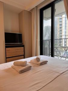 a bedroom with a large bed with towels on it at BW Premium One-Bedroom Apartments in Belgrade