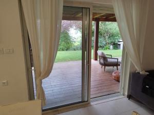 a sliding glass door to a deck with a chair at SnirBen zvi in Kibbutz Snir