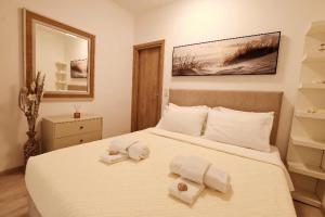 a bedroom with a large white bed with towels on it at Rhodes Beach Side Houses in Ixia
