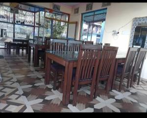 a dining room with wooden tables and wooden chairs at Hariyali Homestay in Sari +12 photos
