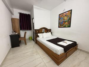 a bedroom with a bed and a desk in a room at Roys Rooms in Kumarakom