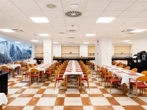 ein Restaurant mit Tischen und Stühlen und einem Schachbrettboden in der Unterkunft Zenit Diplomatic in Andorra la Vella