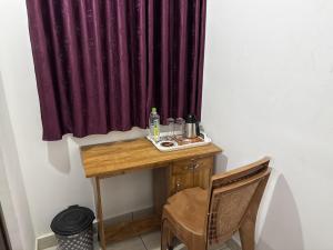 a table in a room with a purple curtain at Roys Rooms in Kumarakom