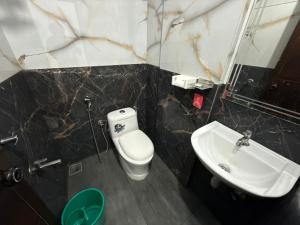 a bathroom with a toilet and a sink at Roys Rooms in Kumarakom +15 photos