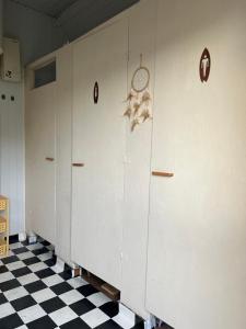 a row of lockers on a wall with a checkered floor at Przyczepa Kempingowa Beige in Jastarnia