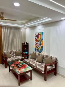a living room with a couch and a table at Petal & Peak Stays in Rājpur