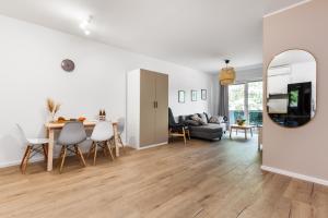 a living room with a table and a couch and a mirror at Apartamenty Pilice - basen, sauny, atrakcje dla dzieci w cenie - 250m in Jastrzębia Góra