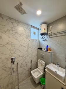 a bathroom with a toilet and a sink at Petal & Peak Stays in Rājpur