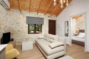 a living room with a couch and a stone wall at Living in in Afitos