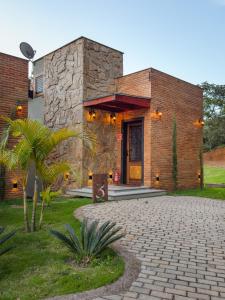 a brick building with a door and a palm tree at Fruto Vermelho Pousada in Pedra Menina