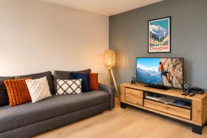 a living room with a couch and a flat screen tv at Apartment Picasso in Chamonix +14 photos