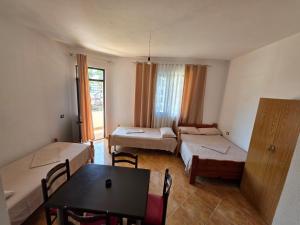 a room with two beds and a table in it at Vila Flamuri in Golem