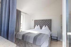 a bedroom with a large bed with blue curtains at Little Paradise in Nova Vas +24 photos
