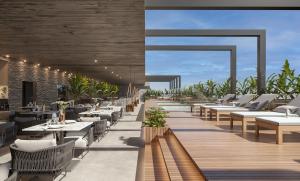 a restaurant with tables and chairs on a deck at Gav resort beach in Salinópolis