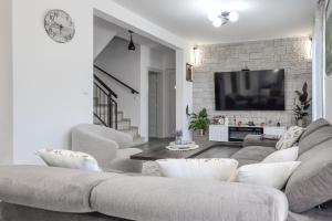 a living room with a couch and a tv at Little Paradise in Nova Vas