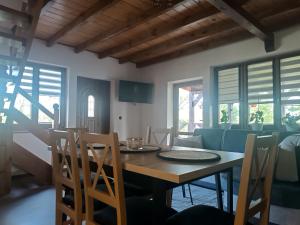 a dining room with a wooden table and chairs at Jesionowy Zakątek domki z balią blisko jeziora in Piasutno