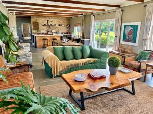 a living room with a green couch and a table at Libertas Guest Farm in Hoekwil