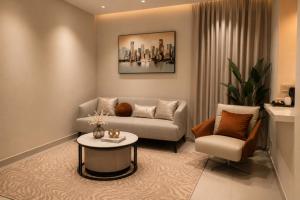 a living room with a couch and a table and a chair at Abu Rakan Apartment in Muscat +80 photos