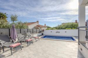 a patio with chairs and a swimming pool at Little Paradise in Nova Vas