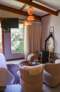 a living room with a couch and a tv at Fruto Vermelho Pousada in Pedra Menina