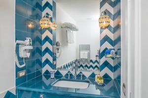 a blue and white bathroom with a sink and a mirror at Milky Suites Positano in Positano