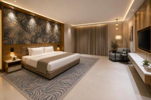 a bedroom with a bed and a couch and a television at Abu Rakan Apartment in Muscat