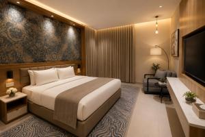 a hotel room with a large bed and a television at Abu Rakan Apartment in Muscat