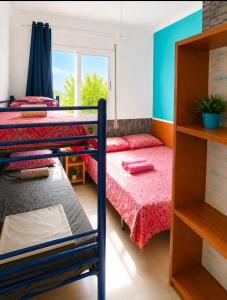 a bedroom with two bunk beds and a window at Pensión Jordi Tossa de Mar in Tossa de Mar