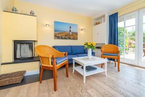 a living room with a blue couch and a fireplace at Haus Düne in List +17 photos