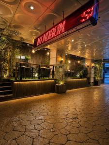 a restaurant with a bar with a red neon sign at Friendly DH Naissance Hotel by Mindrum Group in Seoul