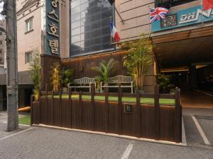 a wooden fence in front of a building at Friendly DH Naissance Hotel by Mindrum Group in Seoul
