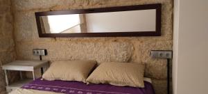 a mirror above a bed in a room at O rincón do Mimo in Ribeira