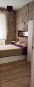 a bedroom with two beds and a brick wall at O rincón do Mimo in Ribeira +14 photos