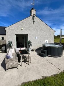 a large patio with a hot tub in front of a building at Andy's Cottages at the Well in Hilltown